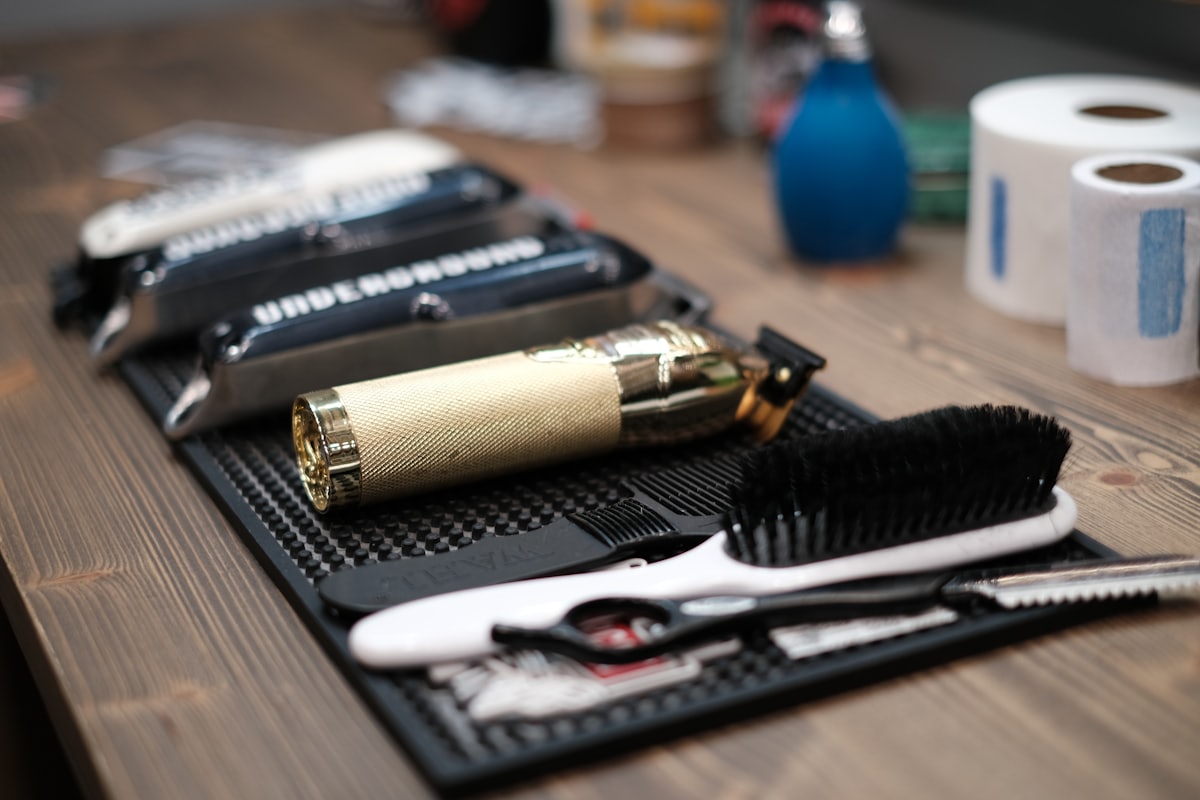 A gold trimmer and brush on the barber's station